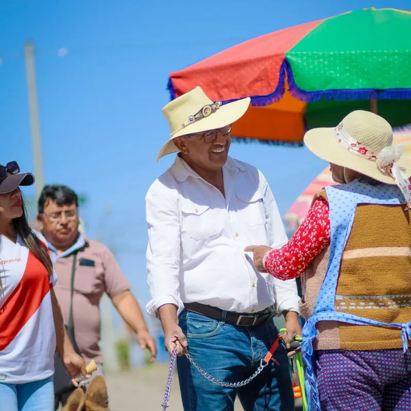 Jaime Chávez conversando con vecinas en un puesto del distrito