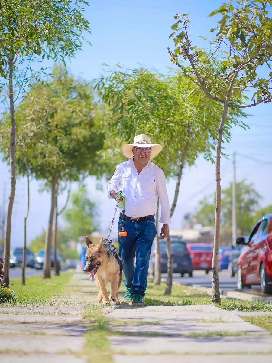 Jaime Chávez caminando con su perro por una calle arbolada de Cayma